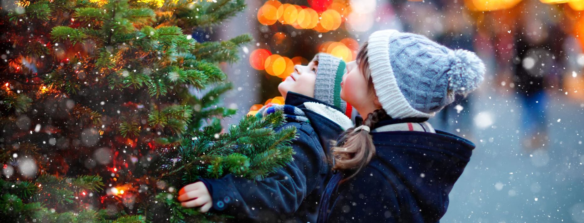 Kinds standing in front of Christmas tree